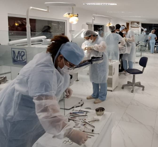 Alunos paramentados e instrumental montado na clínica de cirurgia oral do instituto