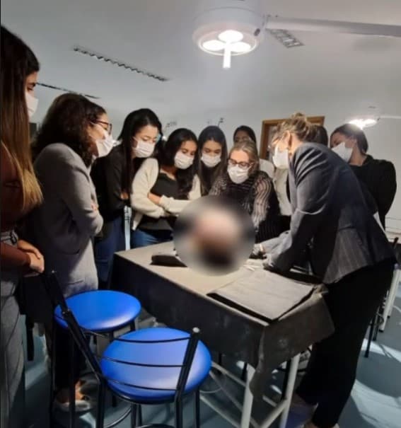 Turma acompanhando de perto uma demonstração prática do professor